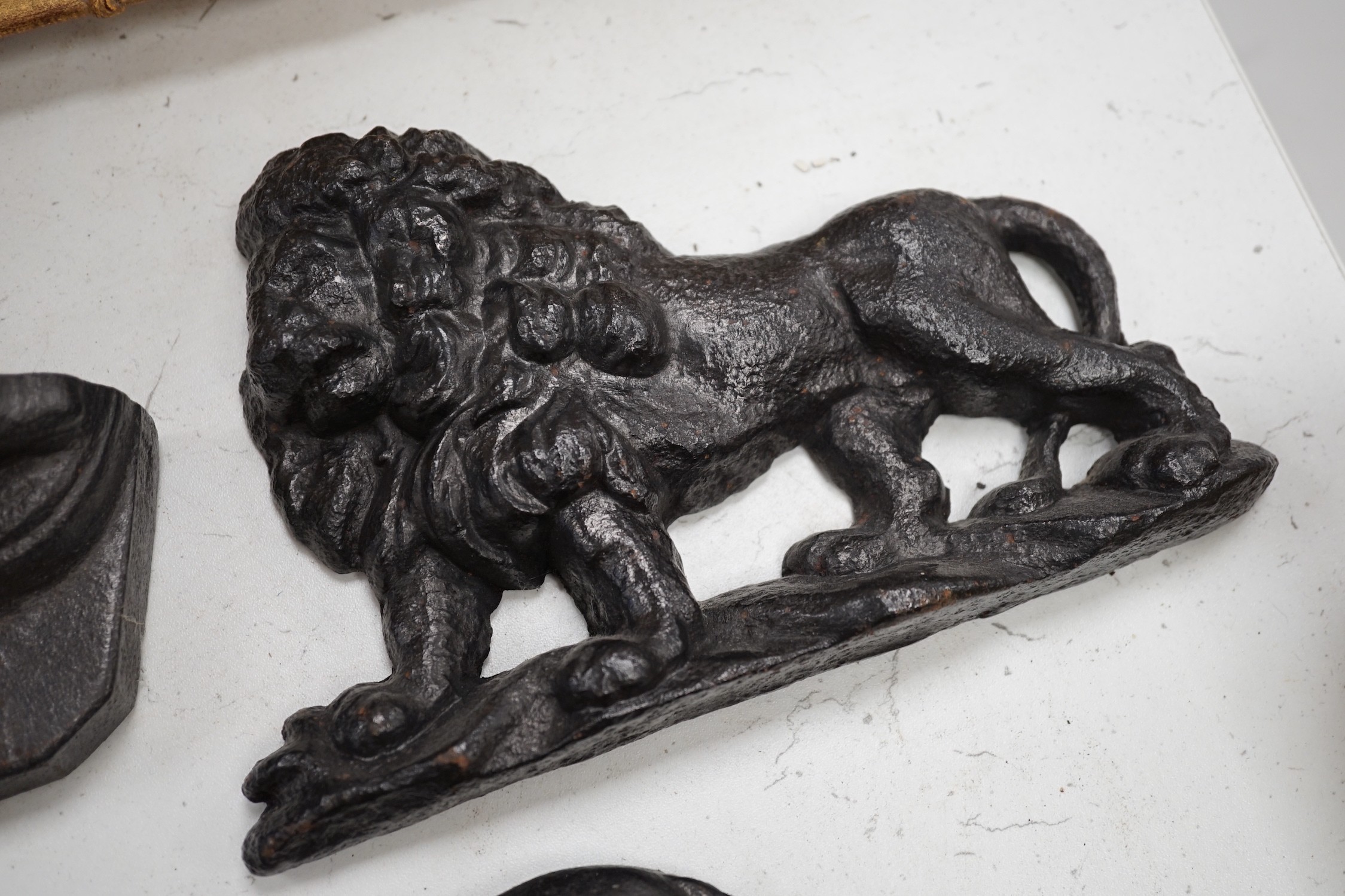 Two lion cast iron door stops, a St Bernard door stop and another, largest St Bernard 18cms high